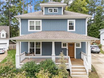 Charming two-story home featuring a welcoming front porch, blue siding, and manicured landscaping at 408 Jerome Rd, Durham, NC 27713