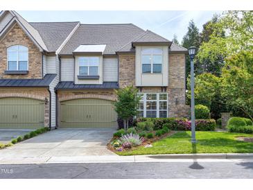 Charming townhome with a stone and siding facade, well-maintained landscaping, and attached two-car garage at 419 Travertine Dr, Cary, NC 27519