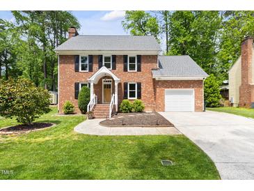 Charming two-story brick home with a well-manicured lawn and attached garage at 4704 Lancashire Dr, Raleigh, NC 27613