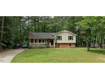 Charming two-story home featuring a welcoming front porch and a well-manicured lawn at 821 Stoneybrook Dr, Sanford, NC 27330