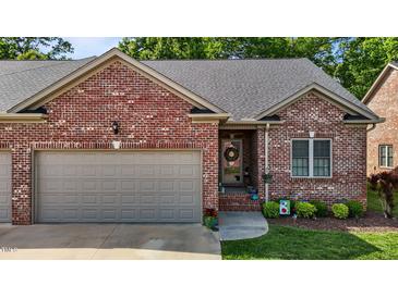 Charming brick home featuring a one-car garage, tidy lawn and inviting front porch at 928 Arrowhead Ln, Mebane, NC 27302
