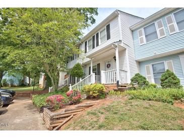 Townhouse exterior showing the covered entrance, colorful landscaping, and a glimpse of the neighboring unit at 10 Grove Park Rd, Durham, NC 27705