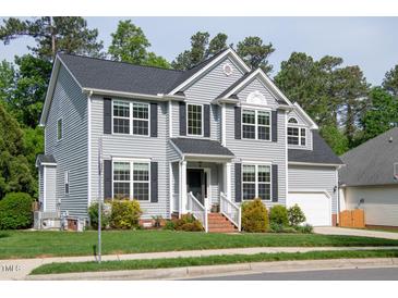 Charming two-story home featuring gray siding, black shutters, well-manicured lawn, and attached garage at 101 Worsham Dr, Chapel Hill, NC 27516