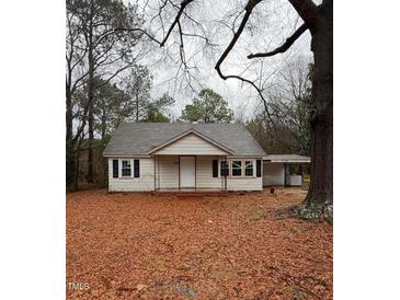 Exterior view of a quaint single-story home with a covered porch and mature trees at 107 E Underwood Ave, Smithfield, NC 27577
