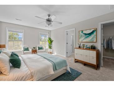 Bright bedroom with neutral walls, ceiling fan, and decorative rug and pillows at 124 Myatt Fern Dr, Garner, NC 27529
