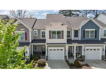 Charming townhome featuring an attached garage, beautiful stonework, and a well-maintained front yard at 124 Myatt Fern Dr, Garner, NC 27529