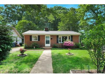 Charming single-story brick home featuring a well-manicured lawn and mature trees at 2709 Farthing St, Durham, NC 27704