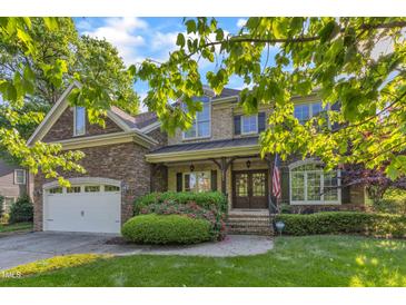 Charming two-story home with stone and brick facade, manicured landscaping, and a welcoming double-door entrance at 3824 Laurel Hills Rd, Raleigh, NC 27612