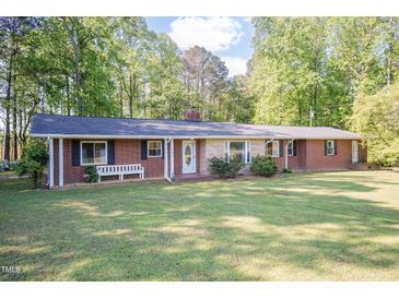 Charming brick home with a well-manicured lawn and a cozy bench near the front entrance at 449 Hill Rd, Franklinton, NC 27525