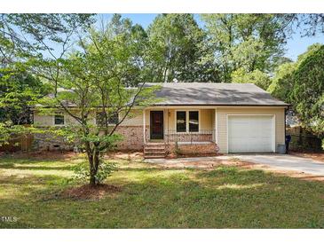 Charming single-story home with brick accents, well-manicured lawn, and an attached garage at 5805 Farm Gate Rd, Raleigh, NC 27606