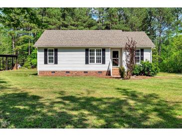 Charming single-story home featuring a well-maintained lawn, classic black shutters, and a welcoming entrance at 7030 Shep Royster Rd, Oxford, NC 27565