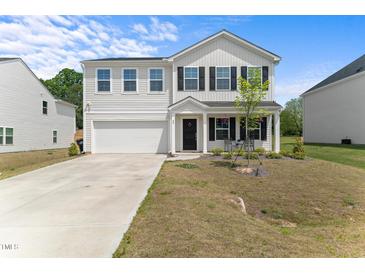 Charming two-story home features a well-maintained lawn, attached garage, and inviting front porch at 80 Spotted Bee Way, Youngsville, NC 27596