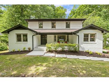 Charming exterior of a white brick home with well-manicured lawn and inviting front porch at 814 Ellynn Dr, Cary, NC 27511
