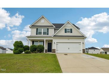 Charming two-story home with a well-manicured lawn and attached two-car garage at 105 Chandon Dr, Princeton, NC 27569