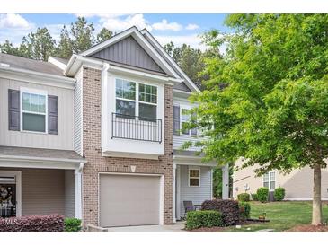 Charming townhouse featuring a brick facade, attached garage, and well-maintained landscaping at 11 Grifton Pl, Durham, NC 27704
