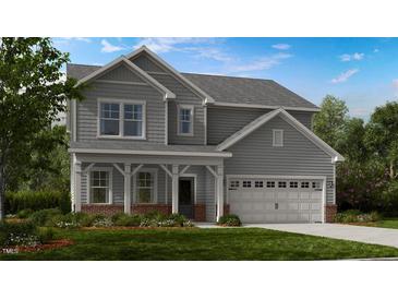 Charming two-story home featuring gray siding, a covered front porch, and an attached two-car garage at 132 Seagraves Creek Ln, Holly Springs, NC 27540