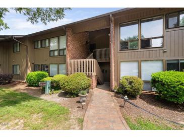A charming two-story townhome with brown siding, brick accents, and a well-maintained landscaped yard at 1504 Oak Tree Dr, Chapel Hill, NC 27517