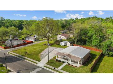 Aerial view of a charming home featuring a metal roof and lush green lawn at 212 Orange St, Oxford, NC 27565