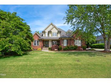 Charming brick home featuring a landscaped front yard, inviting entrance and beautiful curb appeal at 220 Lakecroft Pl, Fuquay Varina, NC 27526