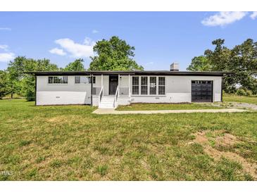 Charming renovated brick home featuring a well-manicured lawn and an attached garage at 2710 E Greensboro Chapel Hill Rd, Snow Camp, NC 27349