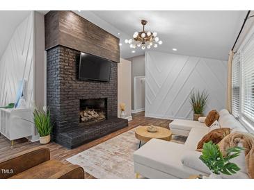 Inviting living room showcases a brick fireplace, dark wood accents, and bright, modern decor at 3725 Fernwood Dr, Raleigh, NC 27612