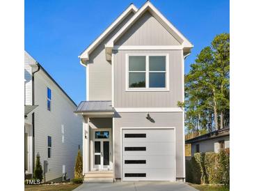 Charming two-story home featuring a modern garage door, stylish gray siding, and a welcoming front entrance at 431 Longfellow St, Fuquay Varina, NC 27526