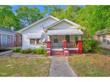 Charming single-story home with a covered front porch and awning-covered windows at 605 Dunbar St, Durham, NC 27701