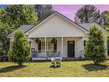 Charming home with a cozy front porch, lush greenery, and well-maintained lawn at 722 E Pine Ave, Wake Forest, NC 27587