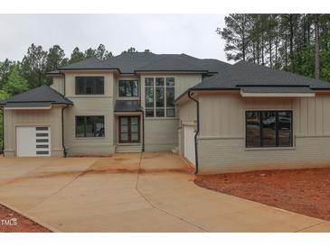 Stunning two-story home featuring brick and siding, an expansive driveway, and multiple garage doors at 7805 Ailesbury Rd, Wake Forest, NC 27587
