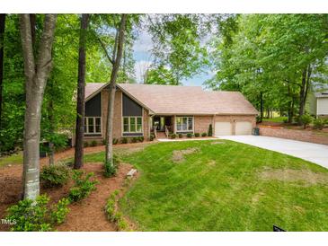Charming brick home with lush green lawn, mature trees, and a two car garage, offering classic curb appeal at 101 Easton Ct, Garner, NC 27529