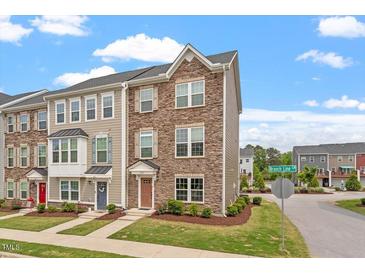 Charming townhouse showcasing a beautifully landscaped front yard and a combination of stone and siding exterior at 1073 Branch Line Ln, Apex, NC 27502