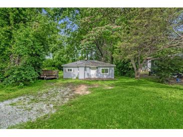 Charming exterior view of cozy home with lush greenery and light-blue painted siding at 1219 Junction Rd, Durham, NC 27704