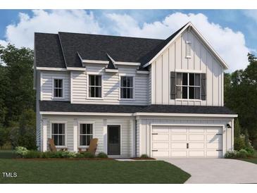 Charming two-story home with a two-car garage, covered entry and well-manicured lawn and landscaping at 1401 Malcus Ct # 58, Fuquay Varina, NC 27526