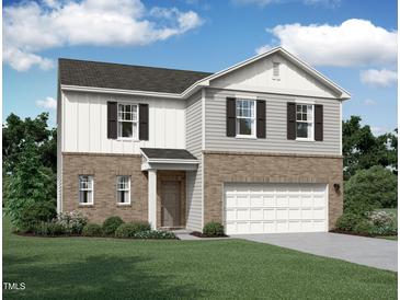Two-story home with brick and siding, complemented by a well-manicured lawn at 145 Gladstone Loop, Clayton, NC 27520