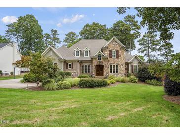 Stunning stone-and-brick home with manicured lawn and mature landscaping at 1605 Hunting Ridge Rd, Raleigh, NC 27615