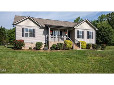 Charming home featuring neutral siding, black shutters, landscaping, and a welcoming porch at 164 Tillburg Ln, Hurdle Mills, NC 27541