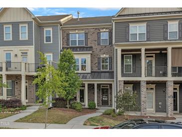 A charming townhouse with brick and siding, complemented by a well-manicured lawn at 1844 Austin Ridge Pkwy, Wake Forest, NC 27587