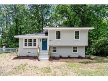 Charming two-story home with light-colored exterior, blue front door, and well-maintained landscaping at 1903 Meadowbrook St, Sanford, NC 27330