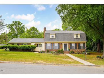 Charming brick home with manicured lawn and mature trees under a blue sky at 2021 Sunnybrook Dr, Burlington, NC 27215