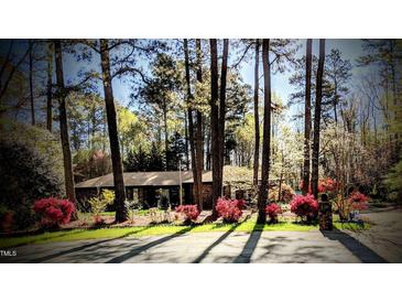 Charming home surrounded by mature trees and flowering shrubs in the front yard at 2100 Possum Trot Rd, Wake Forest, NC 27587
