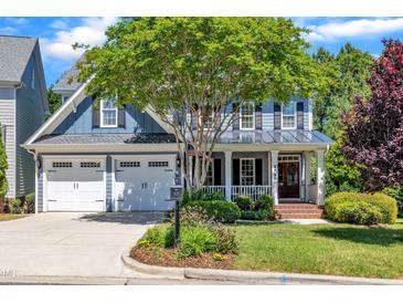 Charming blue two-story home with a covered porch, well-manicured lawn, and a two-car garage at 2723 Cameron Pond Dr, Cary, NC 27519