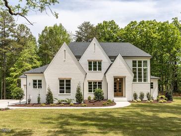 Stunning white brick home with manicured lawn, mature trees, and elegant design at 40 Ridgeline Ct # 10, Pittsboro, NC 27312