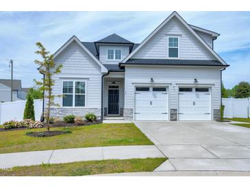 Charming two-story home with manicured lawn, two-car garage, and neutral-colored exterior at 49 Kathy Mae Ct, Angier, NC 27501