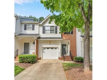 Charming townhome featuring a one car garage, brick accents, and mature tree at 5547 Sea Daisy Dr, Raleigh, NC 27606