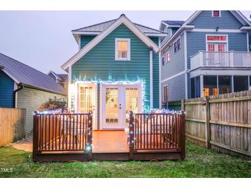 Backyard with wooden deck and festive lighting, perfect for outdoor entertaining at 616 Dorothea Dr, Raleigh, NC 27603