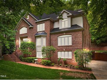 Stately two-story brick home featuring a landscaped front yard and a black shingle roof at 106 Birkhaven Dr, Cary, NC 27518