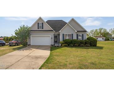 Charming gray home with manicured lawn, complemented by a two-car garage and mature landscaping at 106 Jj Dr, Benson, NC 27504