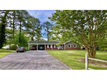 Charming single-story brick home with a covered carport and a spacious front yard at 109 Edgewood Dr, Louisburg, NC 27549