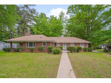 Charming brick home with a well-maintained lawn and mature trees providing shade at 1105 Hargrove St, Henderson, NC 27536