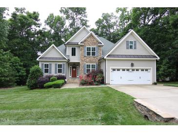 Charming two-story home featuring stone accents, a two-car garage, and a well-manicured lawn at 1108 Kalworth Rd, Wake Forest, NC 27587